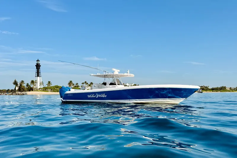 Slide: The Image of 2016 Intrepid 375 Center Console boat on blue ocean near lighthouse and palm trees. - 35