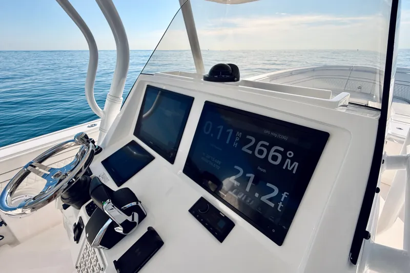 Slide: The Image of Intrepid 375 Center Console 2016 dashboard with navigation screens and steering wheel on open sea. - 65