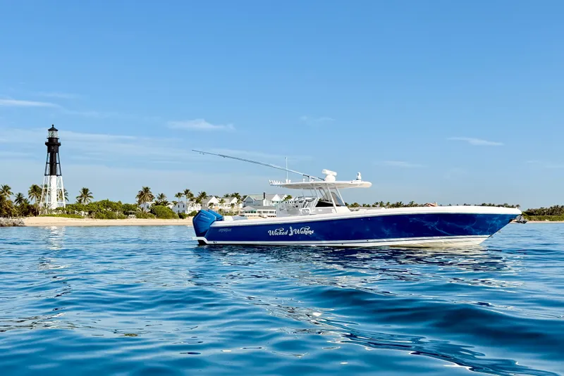 Slide: The Image of 2016 Intrepid 375 Center Console boat near a lighthouse on calm blue waters. - 37