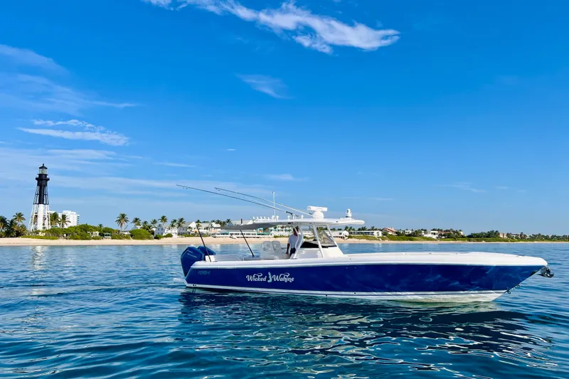 Slide: The Image of 2016 Intrepid 375 Center Console boat on calm waters near a lighthouse. - 47
