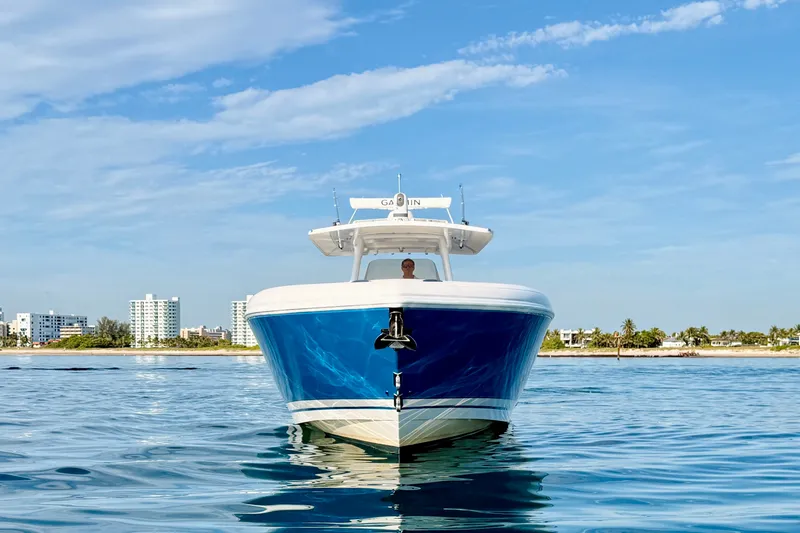 Slide: The Image of 2016 Intrepid 375 Center Console boat on calm water, cityscape in background. - 33