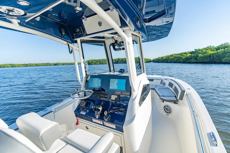 Slide: The Image of Manufacturer Provided Image: 2026 Cobia 245 Center Console boat on calm water, featuring advanced navigation systems. - 8