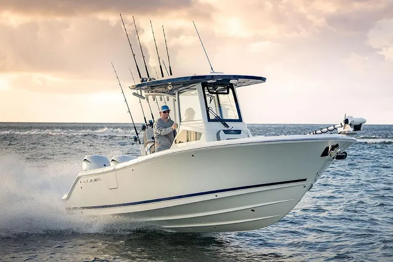 Slide: The Image of Manufacturer Provided Image: 2026 Cobia 245 Center Console boat cruising on open water at sunset. - 0
