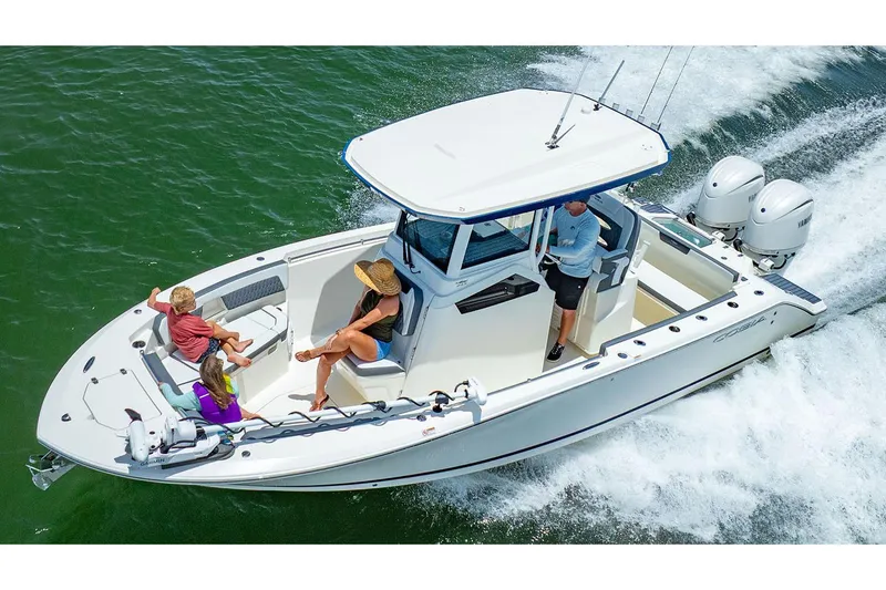 Slide: The Image of Manufacturer Provided Image: 2026 Cobia 245 Center Console boat cruising with passengers on a sunny day. - 2