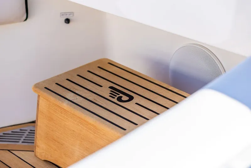 Slide: The Image of Wooden step with logo on 2023 Hinckley 35 boat interior. - 25