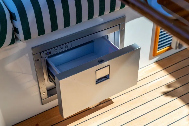 Slide: The Image of Hinckley 35 yacht interior with open drawer fridge, 2023 model, on teak flooring. - 22