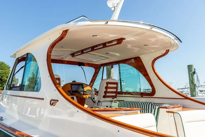 Slide: The Image of 2023 Hinckley 35 yacht interior with elegant wood accents and striped seating. - 14