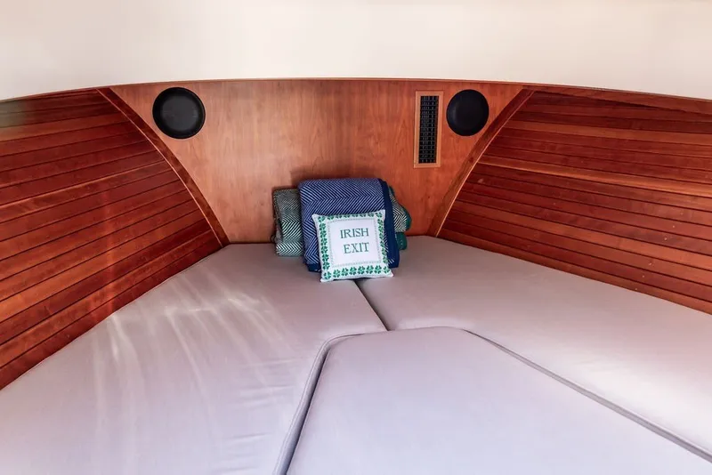 Slide: The Image of 2023 Hinckley 35 cabin interior with wooden paneling and cozy bedding. - 28