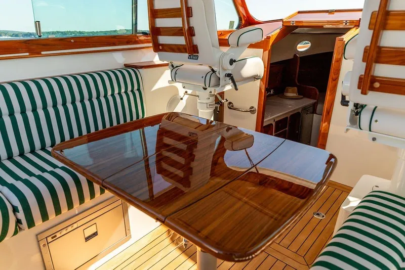 Slide: The Image of Luxurious interior of 2023 Hinckley 35 yacht with striped seating and polished wood table. - 18
