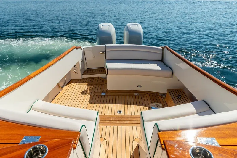 Slide: The Image of Hinckley 35 boat interior, 2023 model, featuring elegant seating and wooden deck on open water. - 26