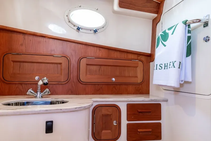 Slide: The Image of Luxurious 2023 Hinckley 35 yacht interior with wooden cabinetry and modern sink. - 30