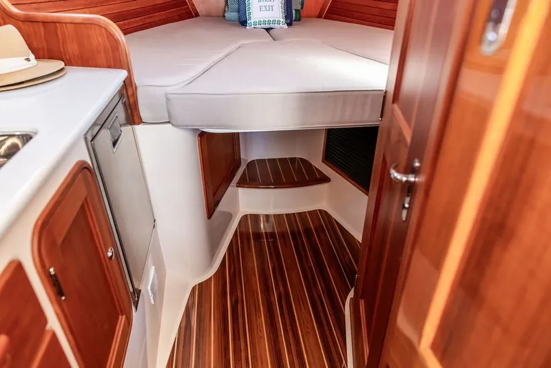 Slide: The Image of Interior of 2023 Hinckley 35 boat with wooden finishes and cozy sleeping area. - 29