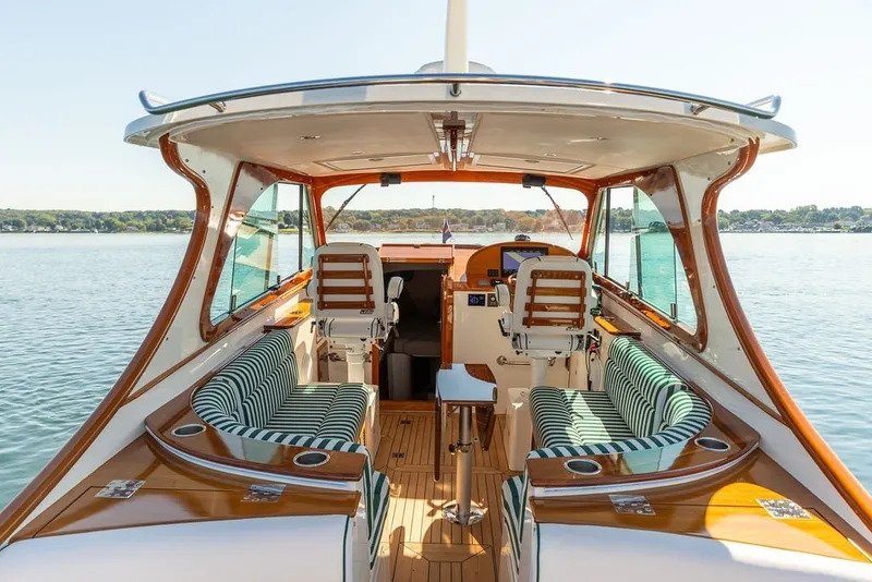 Slide: The Image of Luxurious 2023 Hinckley 35 yacht interior with striped seating and polished wood finish. - 15