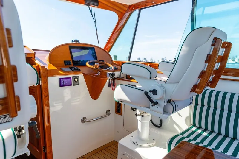 Slide: The Image of Interior of 2023 Hinckley 35 boat with helm, steering wheel, and cushioned seating. - 19