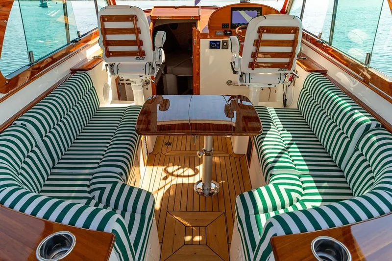 Slide: The Image of Luxurious interior of 2023 Hinckley 35 boat with striped seating and wooden accents. - 17
