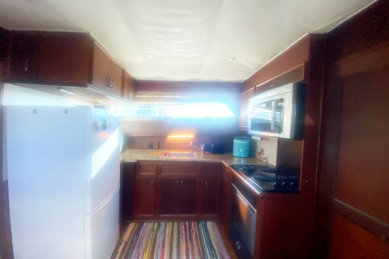 Slide: The Image of Interior kitchen of 1983 Hatteras 53 Motor Yacht with modern appliances and wooden cabinetry. - 23