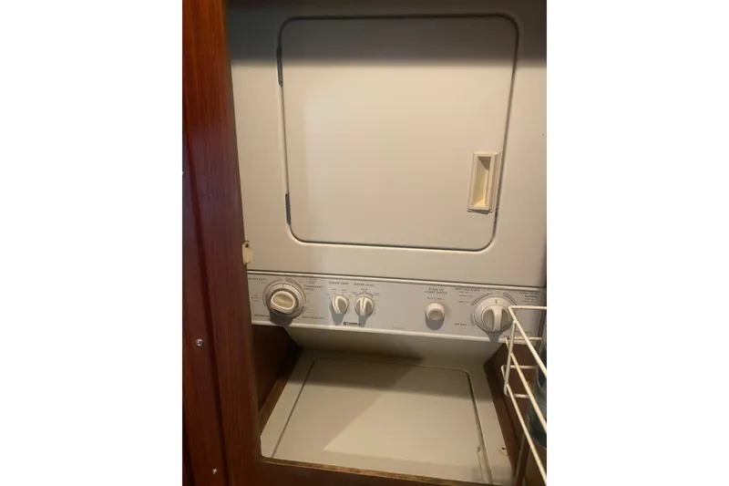 Slide: The Image of Laundry area inside 1983 Hatteras 53 Extended Deckhouse Motor Yacht, featuring a compact washer-dryer unit. - 40