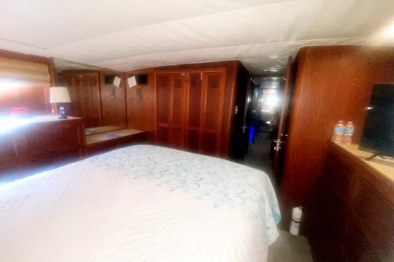 Slide: The Image of Bedroom interior of 1983 Hatteras 53 Motor Yacht with wood paneling and cozy decor. - 37