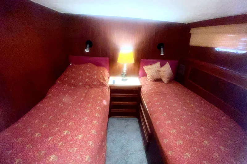 Slide: The Image of Interior of 1983 Hatteras 53 Motor Yacht with twin beds and warm lighting. - 33