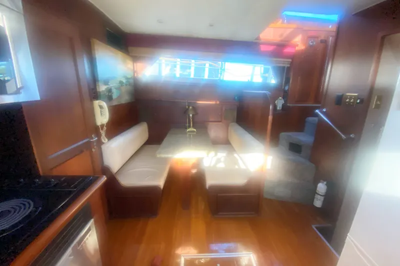 Slide: The Image of Interior of 1983 Hatteras 53 Motor Yacht with dining area and wooden finishes. - 25