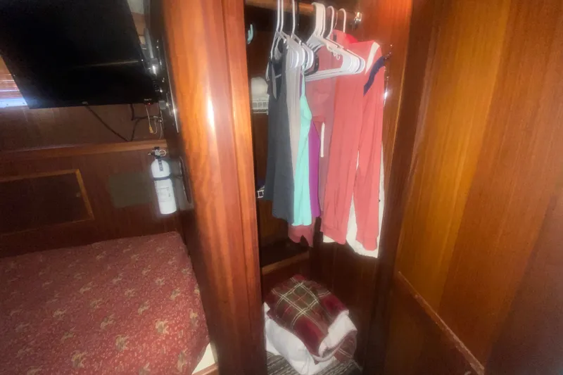 Slide: The Image of Interior of 1983 Hatteras 53 Motor Yacht with wooden closet and hanging clothes. - 34