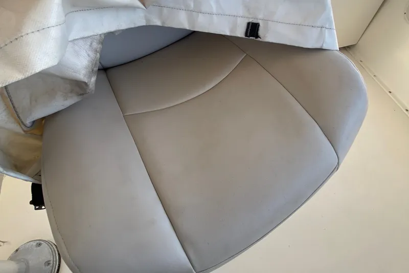 Slide: The Image of White cushioned seat on a 1983 Hatteras 53 Motor Yacht, partially covered. - 52