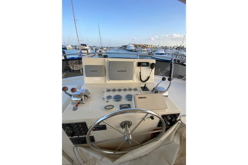 Slide: The Image of Helm of 1983 Hatteras 53 Motor Yacht with navigation equipment and marina view. - 50