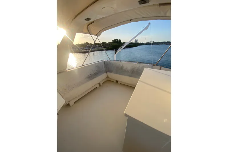Slide: The Image of 1983 Hatteras 53 Motor Yacht interior with sunlit view of water and shoreline. - 53