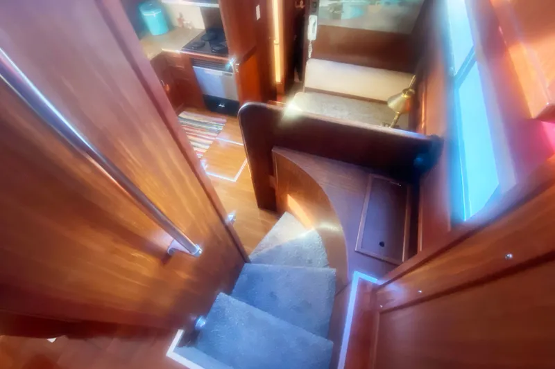 Slide: The Image of Interior view of 1983 Hatteras 53 Motor Yacht, featuring wooden stairs and cozy kitchen area. - 20