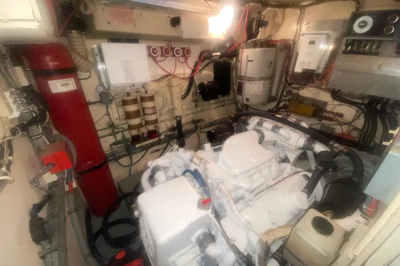 Slide: The Image of Engine room of a 1983 Hatteras 53 Motor Yacht, showcasing mechanical components and wiring. - 41