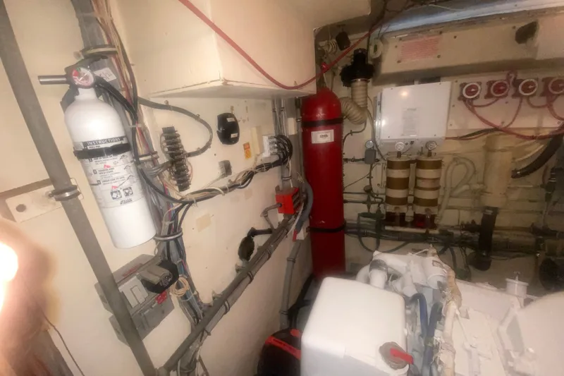 Slide: The Image of Engine room of 1983 Hatteras 53 Motor Yacht with fire extinguisher and wiring. - 43