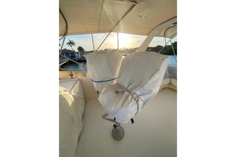 Slide: The Image of 1983 Hatteras 53 Motor Yacht deck with covered chairs at sunset. - 51