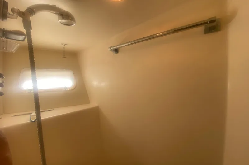 Slide: The Image of Shower area inside 1983 Hatteras 53 Motor Yacht, featuring a window and chrome fixtures. - 31