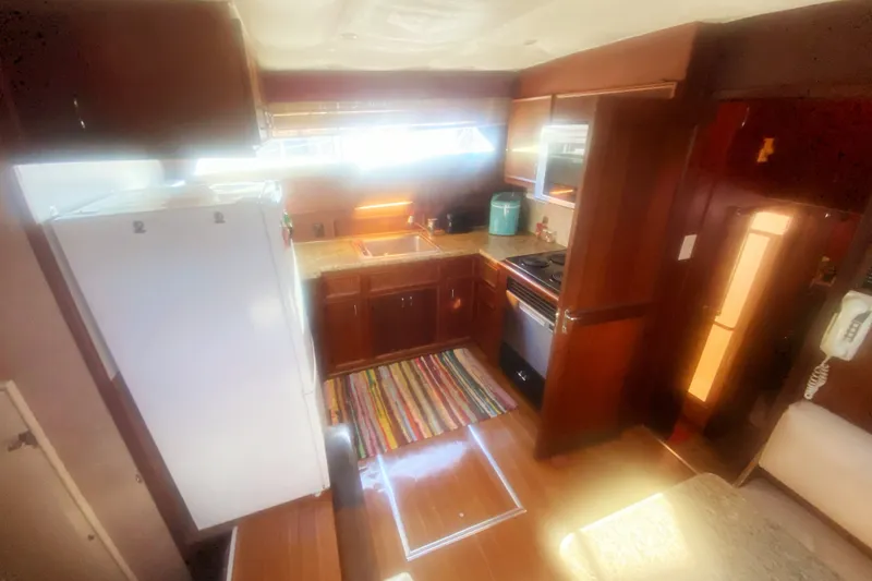 Slide: The Image of Interior of 1983 Hatteras 53 Motor Yacht kitchen with wooden cabinets and modern appliances. - 22