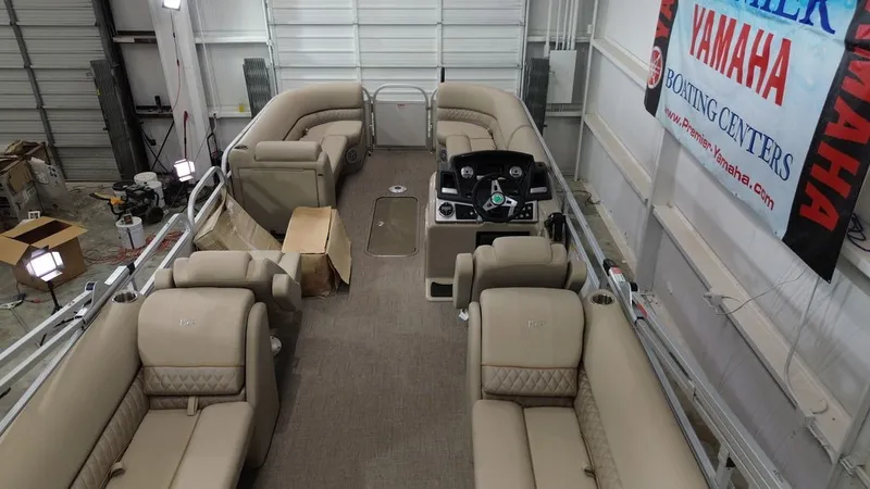 Slide: The Image of The image shows the interior of a Ranger RP243C pontoon boat with beige seating in a warehouse. - 15