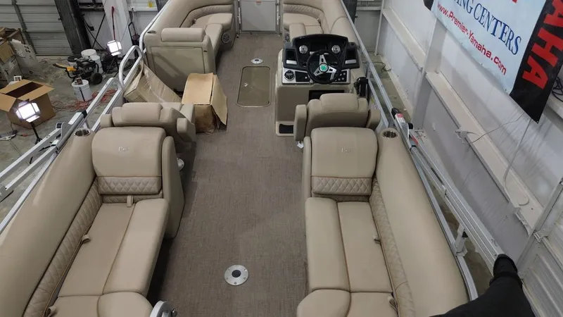 Slide: The Image of The image shows the interior of a Ranger RP243C pontoon boat with beige upholstery and a helm station. - 14