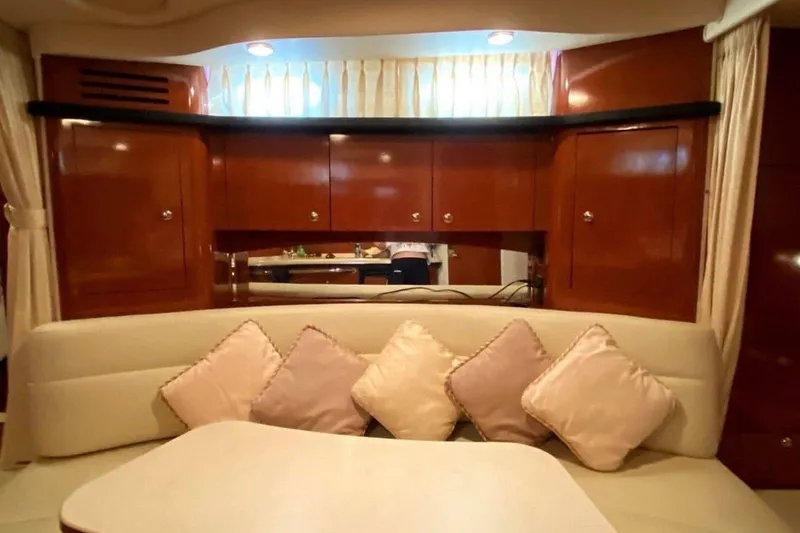 Slide: The Image of Luxurious interior of 2003 Sea Ray 340 Sundancer with plush seating and elegant wood cabinetry. - 4
