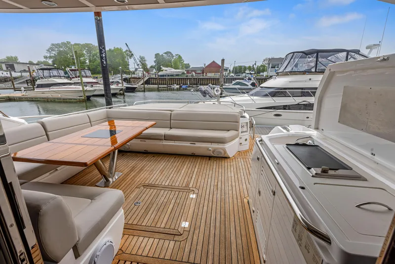 Slide: The Image of Sunseeker Predator 68 (2015) yacht deck with seating, table, and marina view. - 7