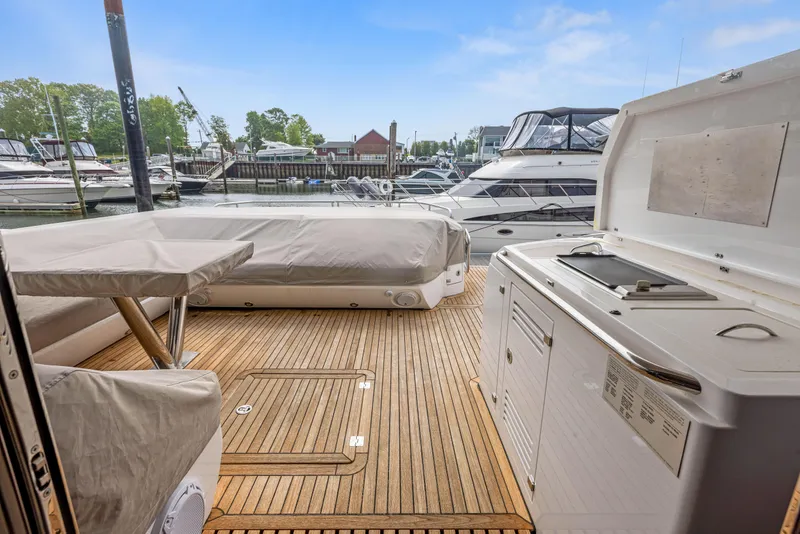 Slide: The Image of Sunseeker Predator 68 (2015) yacht deck with covered seating and dock view. - 8