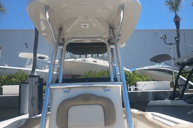 Slide: The Image of 2018 Key West 219 FS boat with T-top, docked near other boats, sunny day. - 15