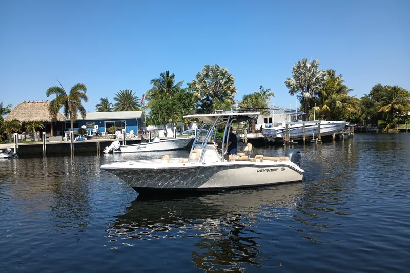 The Image of 2018 Key West 219 FS boat on a calm waterway, surrounded by tropical scenery. - 6