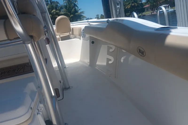 Slide: The Image of 2018 Key West 219 FS boat interior with seating and rod holders, docked by water. - 20