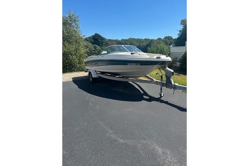Slide: The Image of 2005 Sea Ray 180 Sport boat on trailer, parked on a sunny driveway. - 2