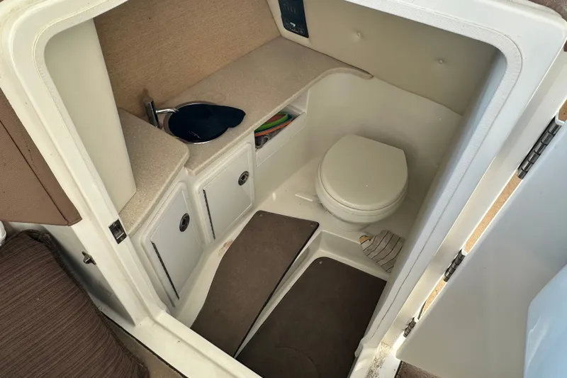 Slide: The Image of 2010 Cobalt 296 boat interior with compact bathroom and sink area. - 13