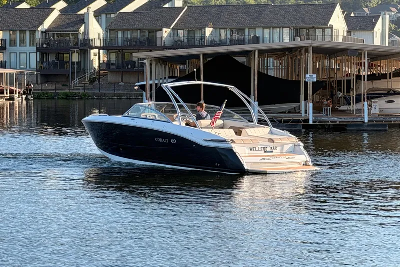 Slide: The Image of 2010 Cobalt 296 boat cruising on a lake near waterfront homes. - 31