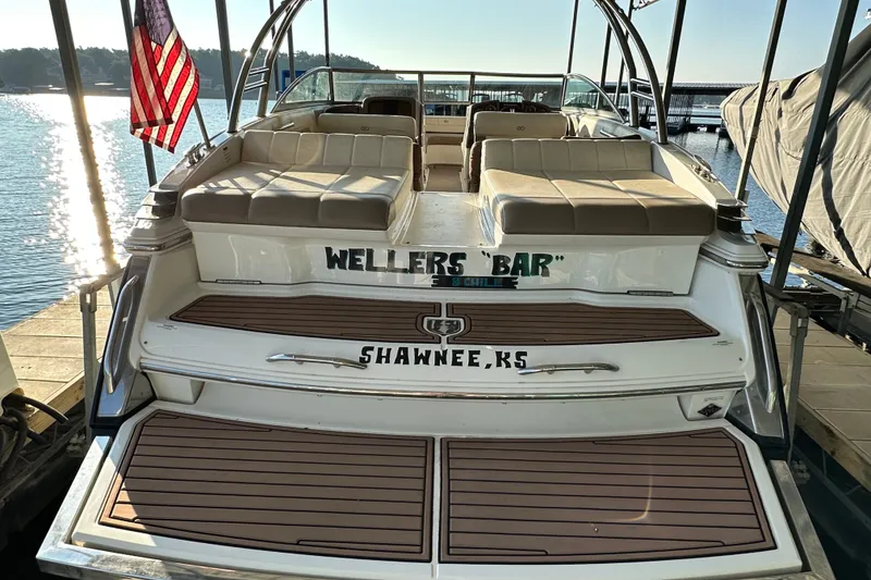 Slide: The Image of 2010 Cobalt 296 boat docked, featuring spacious seating and American flag. - 7
