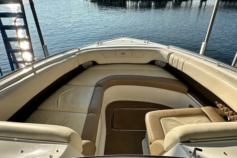 Slide: The Image of 2010 Cobalt 296 boat interior with beige seating, docked by calm water. - 17
