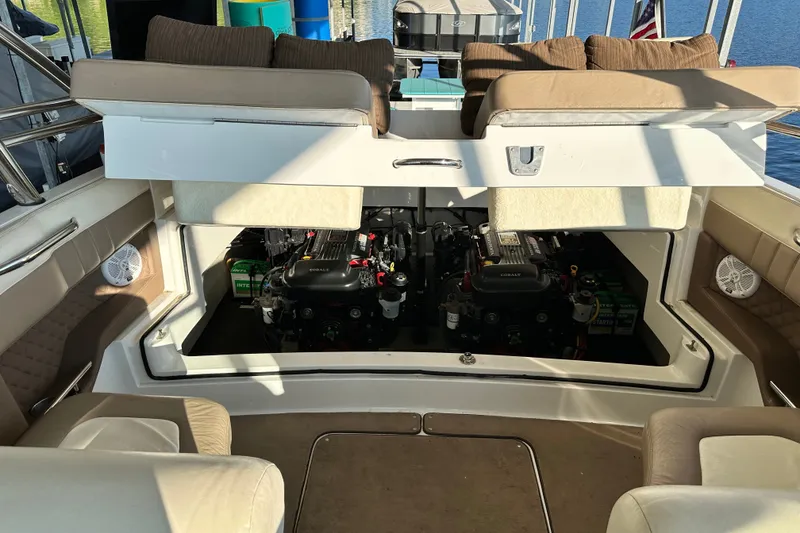 Slide: The Image of 2010 Cobalt 296 boat engine compartment with twin engines and seating area. - 20