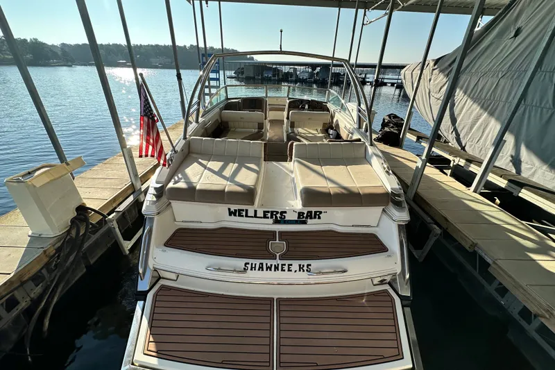 Slide: The Image of 2010 Cobalt 296 boat docked, featuring spacious seating and American flag. - 6