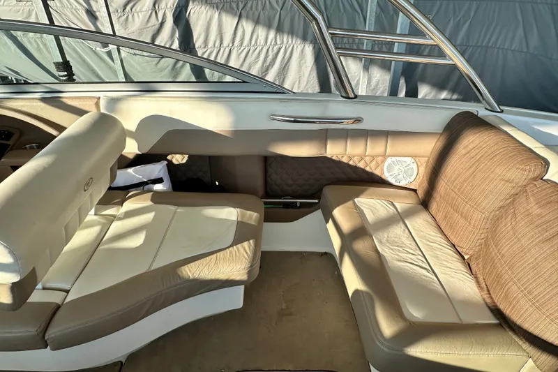 Slide: The Image of Interior of a 2010 Cobalt 296 boat with beige seating and stainless steel accents. - 11